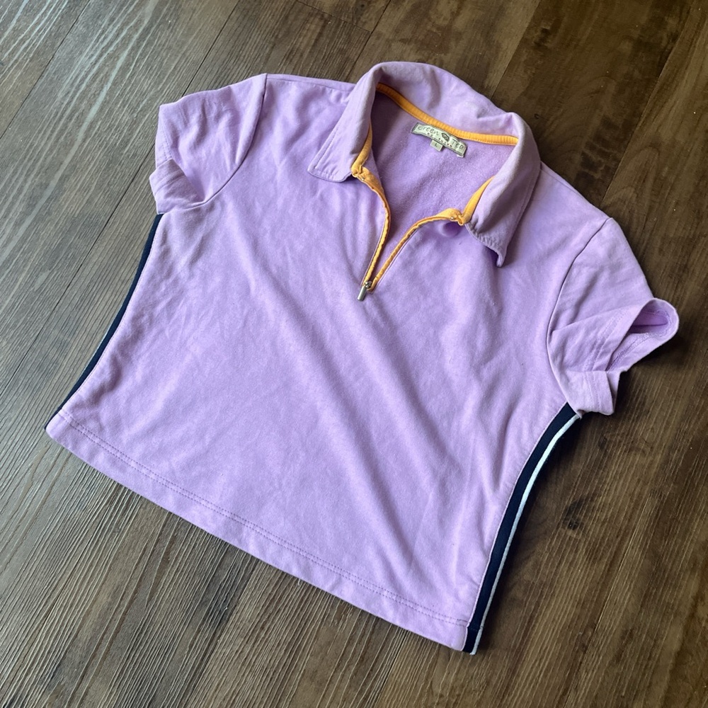 Lavender purple short sleeve polo top with orange contrast zipper.